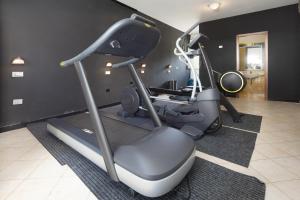 a gym with two exercise bikes and a treadmill at CASA MAJOR Hotel & Appartamenti CERVIA in Cervia