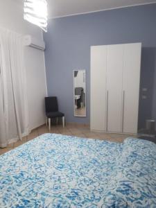 ein Schlafzimmer mit einem großen Bett und einer blauen Decke in der Unterkunft Civico56 in Patti