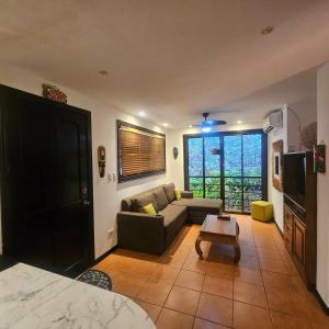 a living room with a couch and a tv at Condo Mono Titi in Quepos