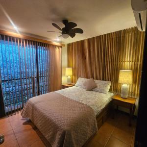 a bedroom with a bed and a ceiling fan at Condo Mono Titi in Quepos