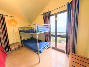 a bunk bed in a room with a balcony at Paul do Mar view in Paul do Mar