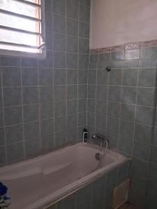 a bath tub in a bathroom with a window at Chez Brahim in Pointe-à-Pitre +1 photo