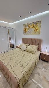 a large bed in a bedroom with a painting on the wall at Olivia Loft in Birmandreis