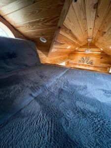 a bed in a room with a wooden ceiling at The Self-Care Tiny Cabin in Parsons