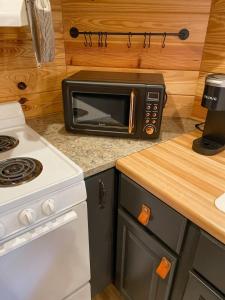 a microwave oven sitting on top of a kitchen counter at The Self-Care Tiny Cabin in Parsons