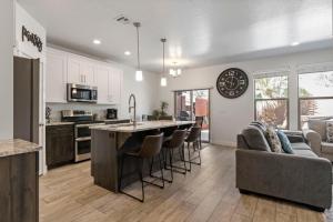 a kitchen and living room with a large island with bar stools at Townhome Near Zion with Hot Tub & Pool in Washington