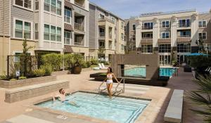 a man and a woman standing in a swimming pool at Madera in Mountain View