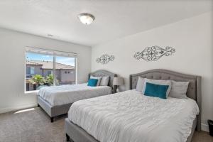 two beds in a bedroom with a window at Townhome Near Zion with Hot Tub & Pool in Washington +28 photos
