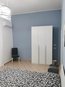 ein Schlafzimmer mit einem Bett und zwei Stühlen in der Unterkunft Civico56 in Patti + 14 Fotos