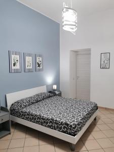 ein Schlafzimmer mit einem Bett mit einer schwarz-weißen Bettdecke in der Unterkunft Civico56 in Patti