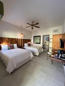 a bedroom with two beds and a ceiling fan at El Encanto Inn & Suites in San José del Cabo