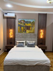 a bedroom with a large white bed with two lamps at ART Dream Hotel in Tashkent