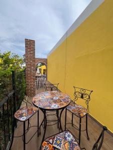a patio with tables and chairs and a yellow wall at El Encanto Inn & Suites in San José del Cabo