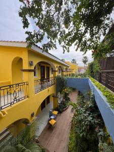a yellow house with a wooden floor and a balcony at El Encanto Inn & Suites in San José del Cabo