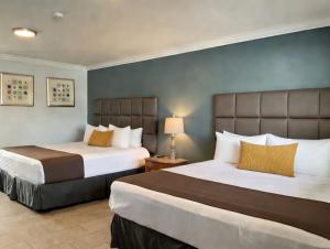 two beds in a hotel room with two beds sidx sidx sidx at Sunrise Inn in Wildwood