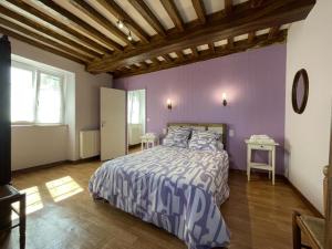 a bedroom with a bed with purple walls and a wooden ceiling at Etchechoury in Moncayolle-Larrory-Mendibieu