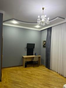 a room with a chandelier and a desk and a television at ART Dream Hotel in Tashkent