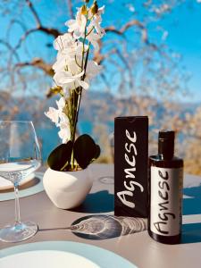 a table with a glass of wine and white flowers at Casa Agnese Lake View in Brenzone sul Garda