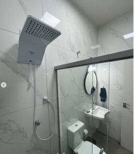 a bathroom with a shower and a toilet and a sink at N 40 - Central com 2 quartos, ar condicionado e garagem in Cascavel
