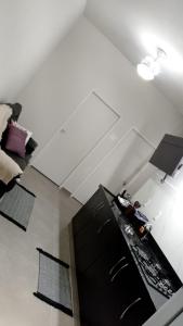 a living room with a ceiling and a black cabinet at N 40 - Central com 2 quartos, ar condicionado e garagem in Cascavel +9 photos