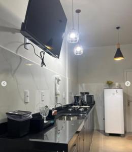a kitchen with a sink and a stove and a refrigerator at N 40 - Central com 2 quartos, ar condicionado e garagem in Cascavel