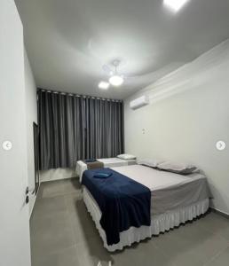 a bedroom with two beds and a window at N 40 - Central com 2 quartos, ar condicionado e garagem in Cascavel