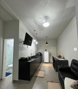a living room with a couch and a kitchen at N 40 - Central com 2 quartos, ar condicionado e garagem in Cascavel