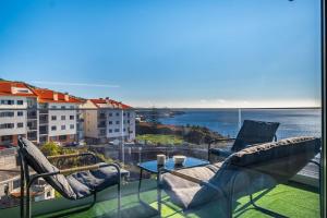 a balcony with chairs and a view of the ocean at Endless Horizon BY YOUR KEY MADEIRA in Santa Cruz