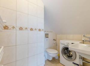 a bathroom with a toilet sink and a washing machine at Ryn - Rybical Resort in Rybical +37 photos