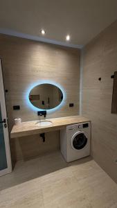 a bathroom with a sink and a washing machine at Solemar4 in Vlorë +36 photos