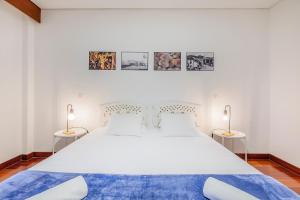 a bedroom with a large white bed with two lamps at HI Douro Alijó - Pousada de Juventude in Alijó +60 photos