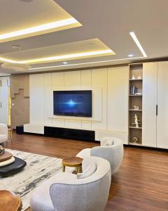 a living room with two chairs and a tv at The Mansion in Abuja