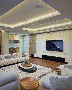a living room with couches and a flat screen tv at The Mansion in Abuja