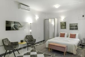 a bedroom with a large bed and two chairs at S&P City Center Apartments in Kotor
