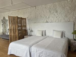 a bedroom with a large white bed in a room at Casa do Cacto - Studio Flat in Madalena