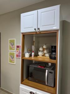 a kitchen with a microwave in a cabinet at Dpto centro CDE in Ciudad del Este
