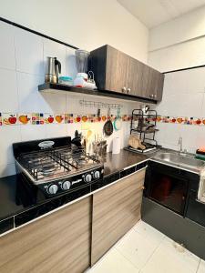 a kitchen with a stove and a sink at Apartamento cerca a la Basilica Buga valle in Buga