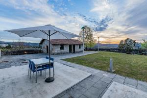 a table and chairs with an umbrella on a patio at HI Douro Alijó - Pousada de Juventude in Alijó