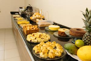 a buffet line with pastries and cakes and other desserts at Paramirim Palace Hotel in Paramirim +13 photos
