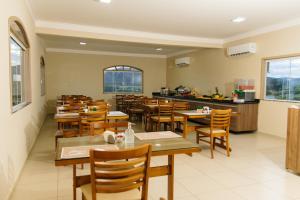 an empty restaurant with wooden tables and chairs at Paramirim Palace Hotel in Paramirim