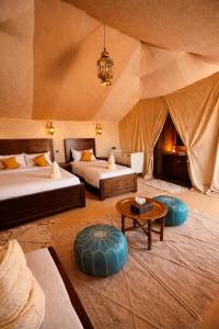 a bedroom with two beds and a tent at Hidden luxury Camp in Merzouga