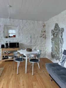 a living room with a white table and chairs at Casa do Cacto - Studio Flat in Madalena