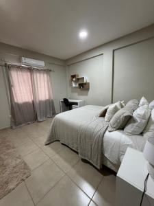 a bedroom with a large bed and a desk at Dpto centro CDE in Ciudad del Este