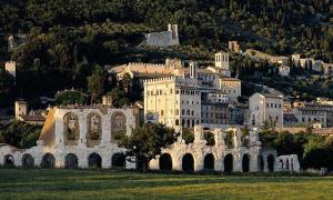 a large building on top of a green field at Casa Peppina in Gubbio