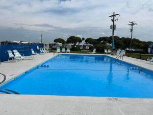 a large blue swimming pool with chairs around it at Catchin Rays in North Topsail Beach
