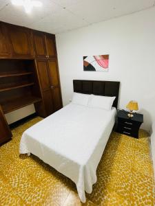 a bedroom with a bed with a white bedspread at Apartamento cerca a la Basilica Buga valle in Buga