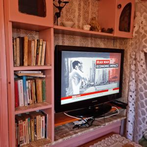 a tv sitting in a book shelf at Momo's villa 2nd room in Aït Ourir
