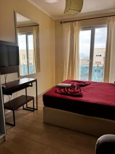 a bedroom with a bed and a desk and a window at Inis apartamans -50 m from beach in Shëngjin