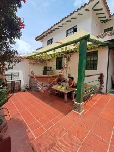 a man sitting on a hammock in front of a house at H-OSTELLO LA MERIDIANA in Villa de Leyva