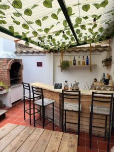 a kitchen with a bar with four chairs and a counter at H-OSTELLO LA MERIDIANA in Villa de Leyva